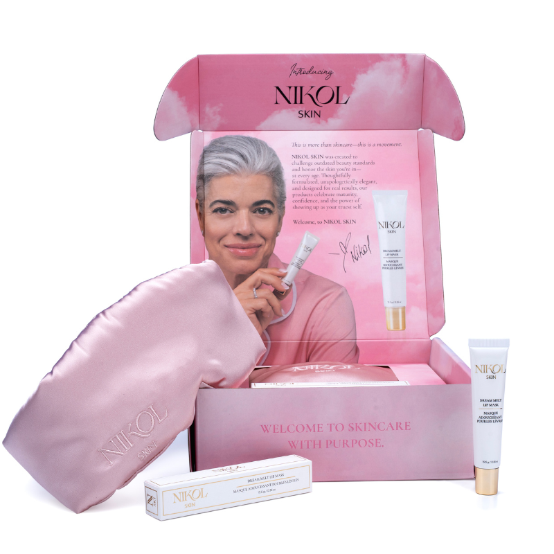 An open pink Shopgalaxys box displays a satiny sleep mask, a skincare tube, and product packaging. Inside the lid is a photo of a smiling person holding a Dream Melt Lip Mask tube with a welcome message printed beside them.