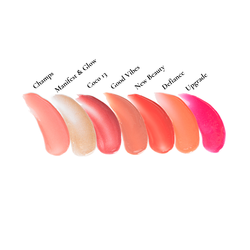 Seven lipstick swatches from the Shopgalaxys Lip Gloss Collection are shown on a white background. Named Champs, Manifest & Glow, Coco 13, Good Vibes, New Beauty, Defiance, and Upgrade, the shades vary from light peach to bright pink—ideal for enhancing any luxury gift box.