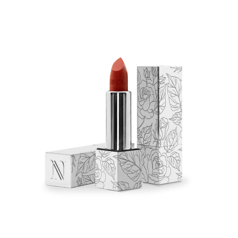 The Confidence Shiny Velvet Cream Lipstick #173 by Shopgalaxys, with its ultra-creamy texture, stands upright, partially uncapped. The cap beside it showcases a floral pattern and an N, highlighting its hydrating effect on mature lips.