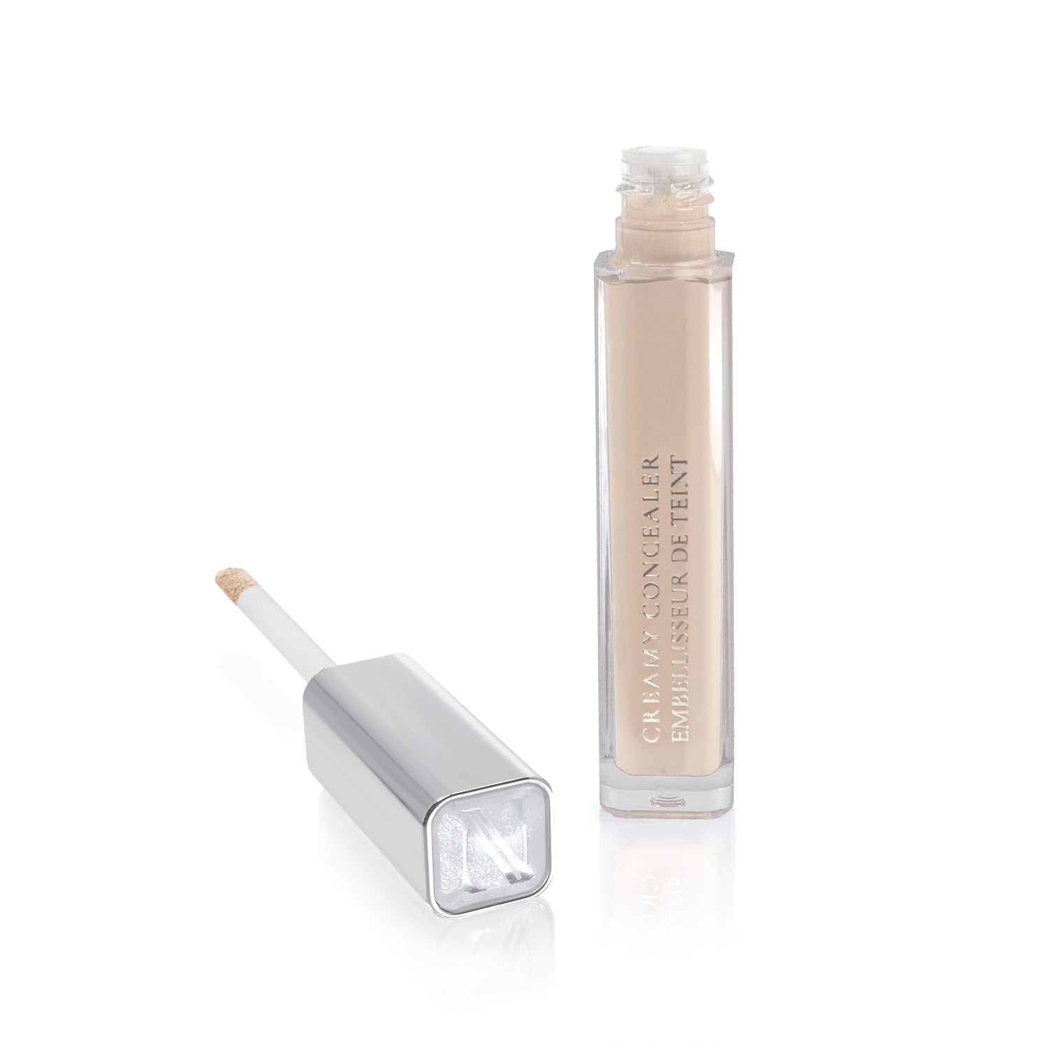 A tube of Shopgalaxyss Creamy Concealer, featuring a square silver cap, reveals an applicator wand when removed. This high-coverage light beige concealer is perfect for makeup application and stands elegantly on a reflective white surface, accentuating its sleek design.