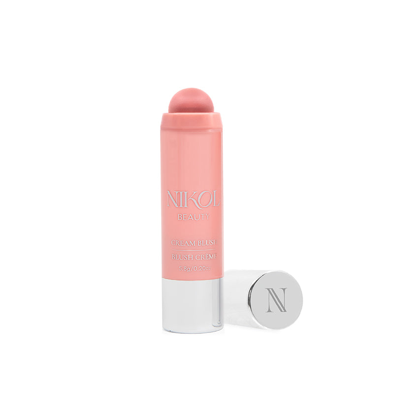 A pink Cream Blush Stick from Shopgalaxys, slightly rolled up to reveal its creamy texture ideal for mature skin, stands upright beside its silver cap embossed with an N, displaying the products name and weight.