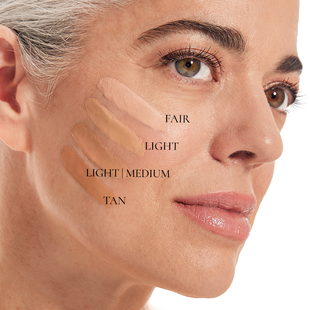 A womans neutral face features swatches of Shopgalaxyss BB CRÈME, enriched with hyaluronic acid, in shades Fair, Light, Light/Medium, and Tan on her cheek to showcase diverse skin tones.