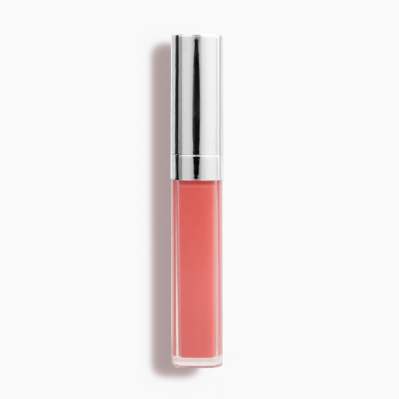 The New Beauty Lip Gloss #282 by Shopgalaxys features a clear body revealing a muted pink hue with a metallic silver cap. Infused with avocado oil, it delivers high-impact shine. The tube stands vertically on a white surface, casting a shadow to the left.