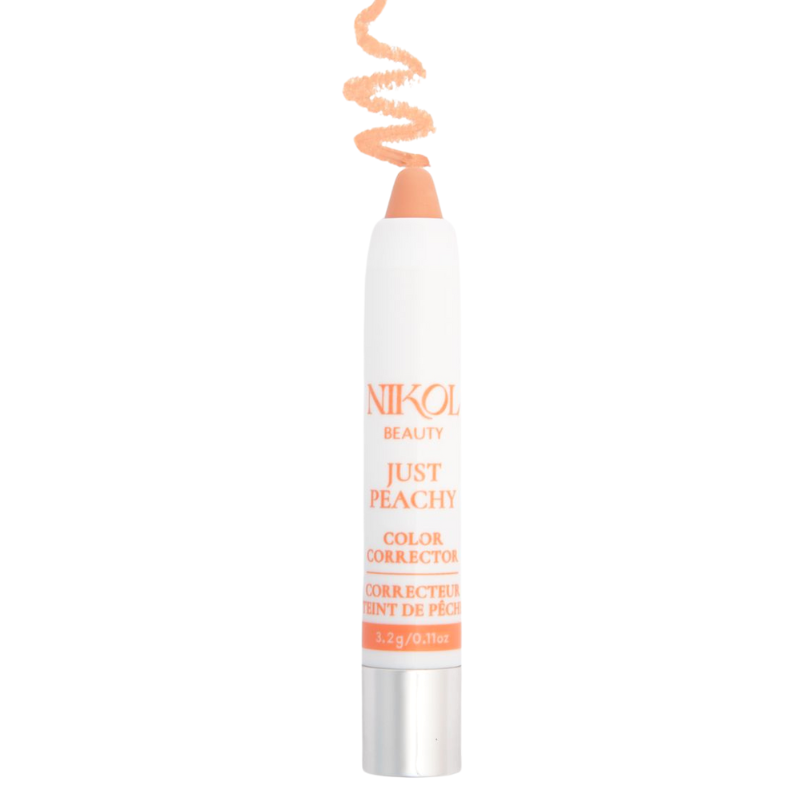 The Shopgalaxys Just Peachy Color Corrector is a white stick with a peach tip, designed for undereye discoloration. It features a silver cap and has a decorative peach swirl above the stick.