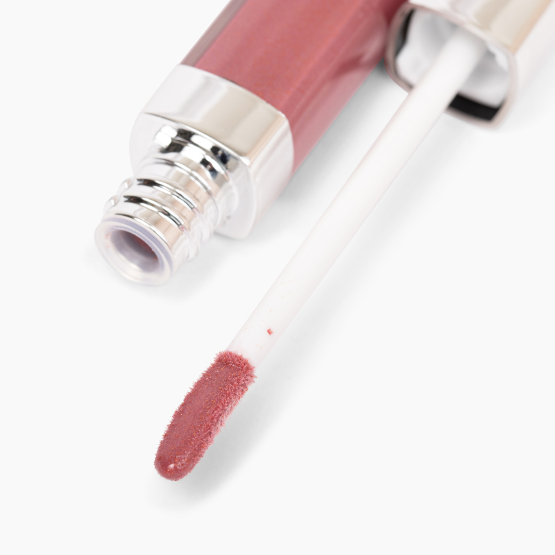 A close-up of Shopgalaxyss Coco 13 Lip Gloss #259 reveals a shimmering pink doe-foot applicator. Its high-impact shine enhances lips, while the metallic accent at the opening lends elegance, embodying clean beauty standards.