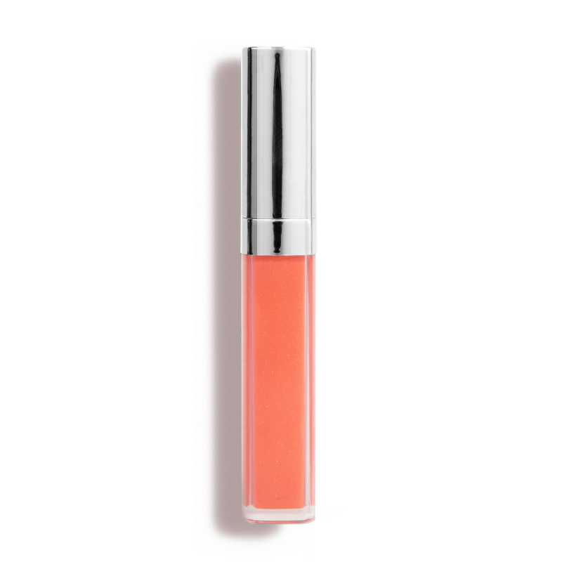 A tube of Shopgalaxyss Defiance Lip Gloss #62, coral-colored with a shiny silver cap, known for its high-impact shine and non-sticky finish, stands upright against a white backdrop.