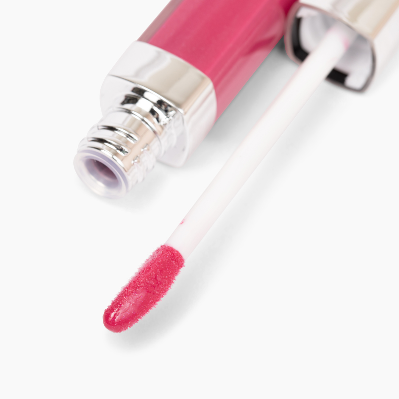 A close-up of Shopgalaxyss Upgrade Lip Gloss #94, a cruelty-free pink gloss with a silver cap, features an applicator wand coated in shiny pink color, set against a white background.